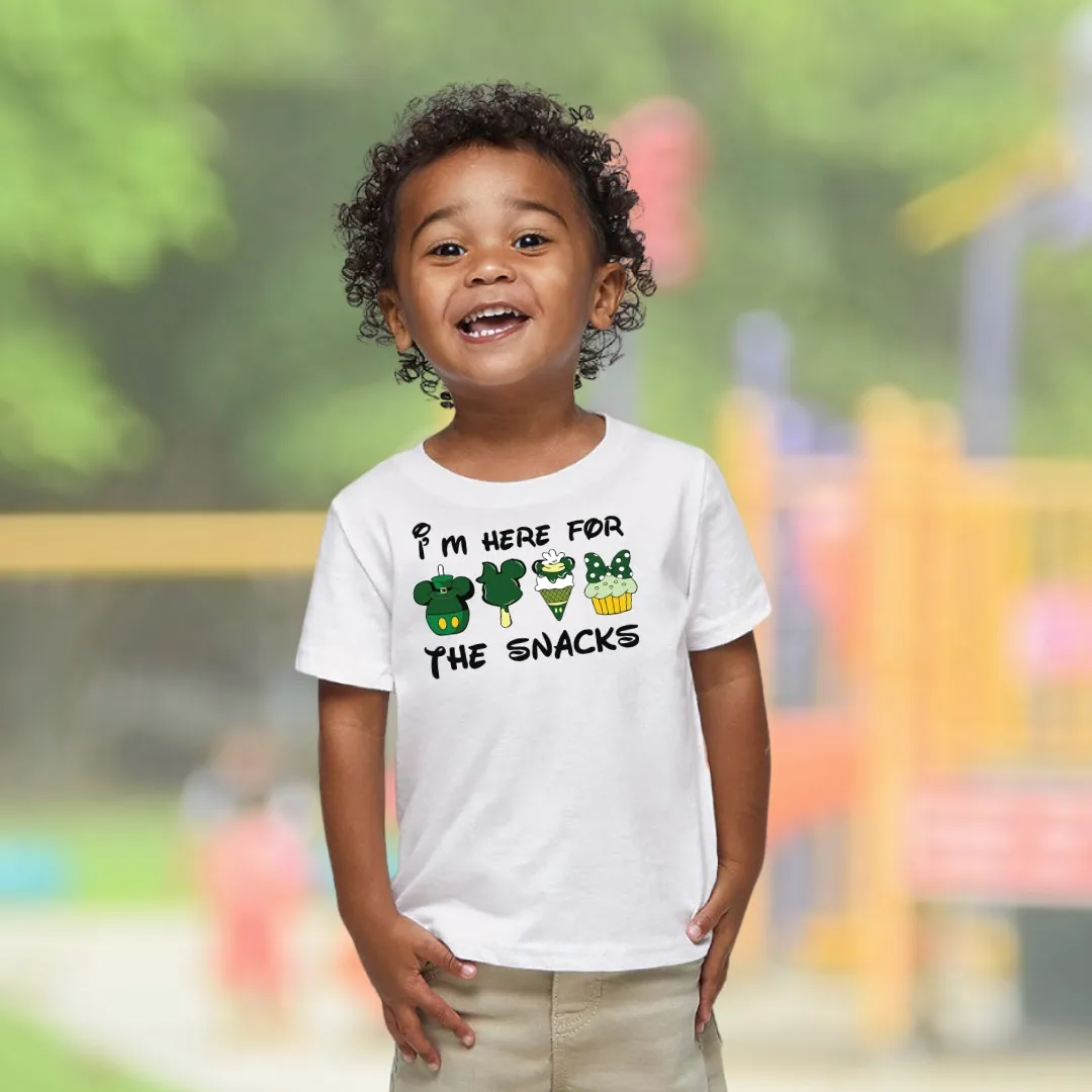 Smiling child wearing Nielseun white t-shirt with playful I'm Here for the Snacks print at playground